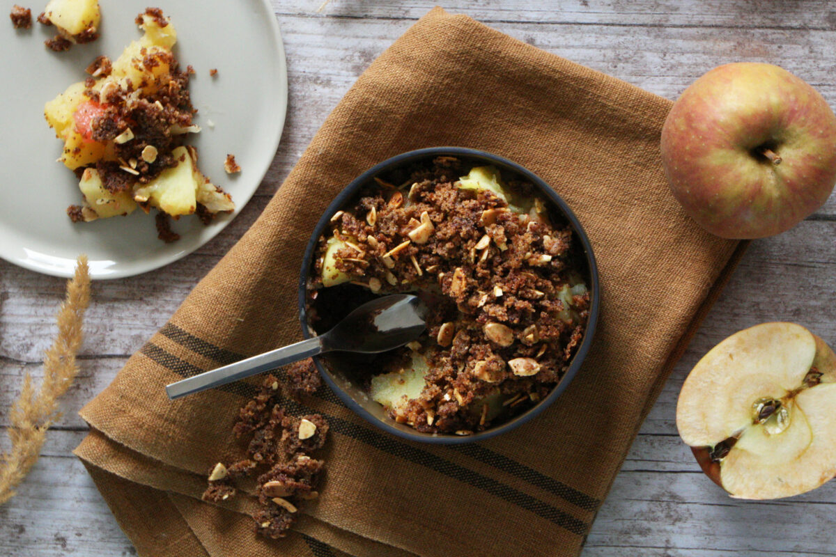 un bol de pommes et de granola avec une cuillère.