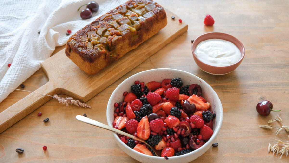 un bol de baies et un bol de yaourt, garnis de crème chantilly.