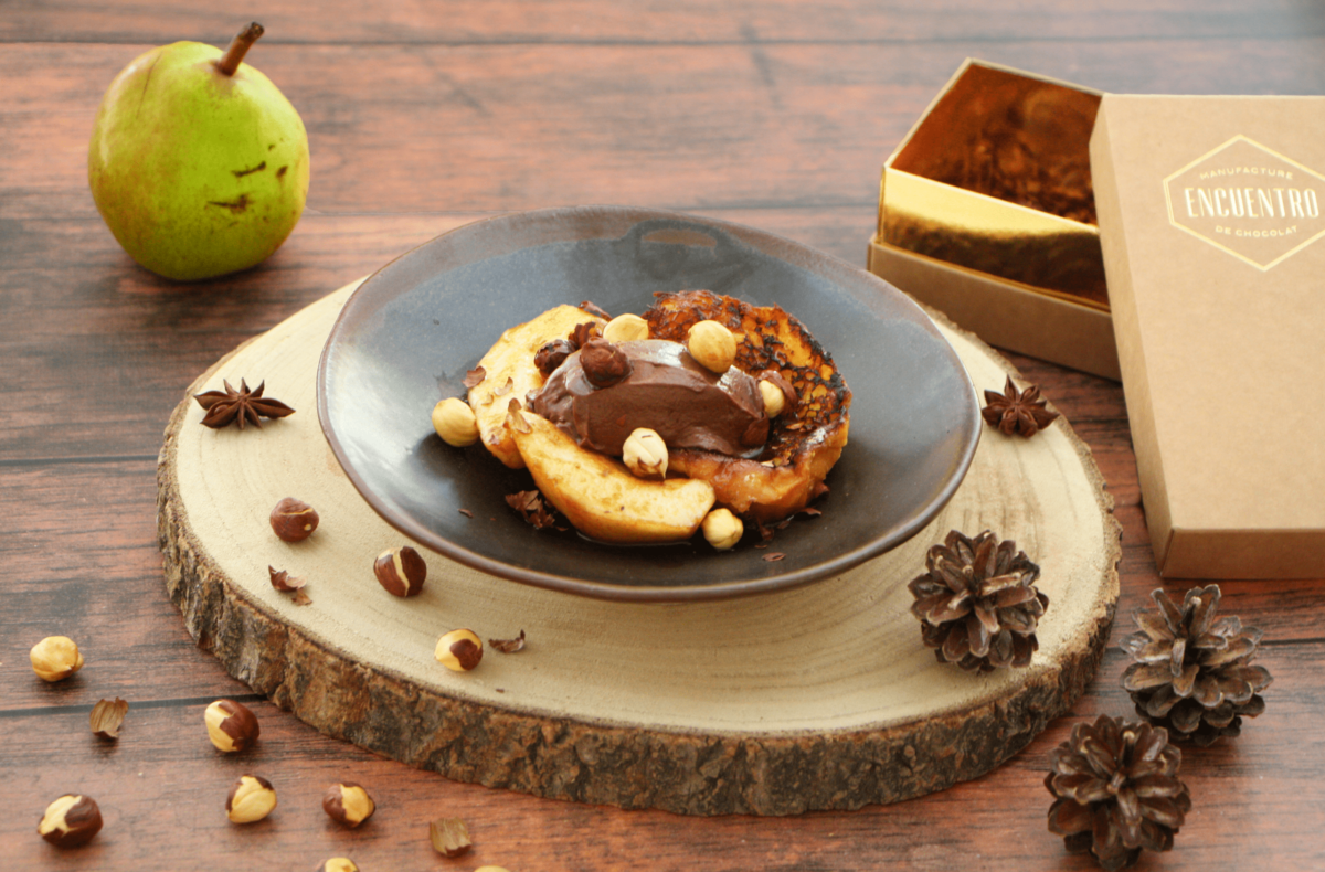 une assiette de poires au sirop sur une table à côté d'une boîte.